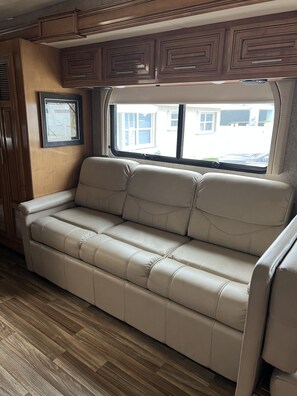 Relax in comfort with a sofa against a wall featuring a window with a view.