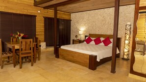 A wooden bedroom with a bed, a desk, and chairs. - Loma de Sion (San Francisco de Macorís)