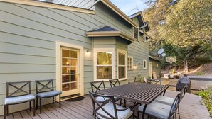 A wooden deck with a table and chairs, a door, and a satellite dish.