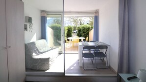 A room with a sliding glass door leading to an outdoor patio with a table and chairs.