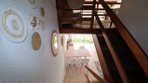 Una scala conduce a una sala da pranzo con un tavolo e sedie in legno.