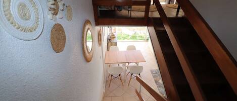 Een trap die leidt naar een eethoek met een houten tafel en stoelen.