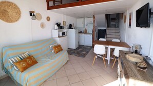 Un'accogliente zona giorno con divano, tavolo da pranzo e cucina sullo sfondo.
