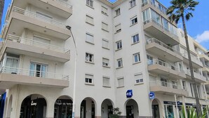 A multi-story hotel with balconies, a central courtyard, and a sign indicating a location. - 2-Bedroom Apartment Close to the Beach, Shops, Entertainment  5CDUSUD1 (CANET PLAGE)