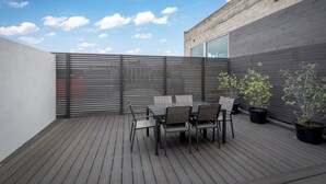 A rooftop patio with a wooden deck, a table with chairs, and potted plants. - Brisbane Terrace - Hobart Inner City - Free Parking - Free WIFI (Hobart)