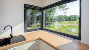 Eine moderne Küche mit großem Fenster, einer Spüle und einer Arbeitsplatte.