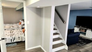 A modern living room with a staircase leading to a bedroom.