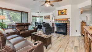 A spacious living room with leather sofas, a coffee table, and a fireplace with decorative tiles. - Casa de la Paloma -  Peaceful Golf Course Luxury Retreat (Tucson)