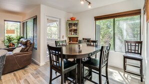 A dining area with a round table, six chairs, and a cabinet with glass doors. - Casa de la Paloma -  Peaceful Golf Course Luxury Retreat (Tucson)