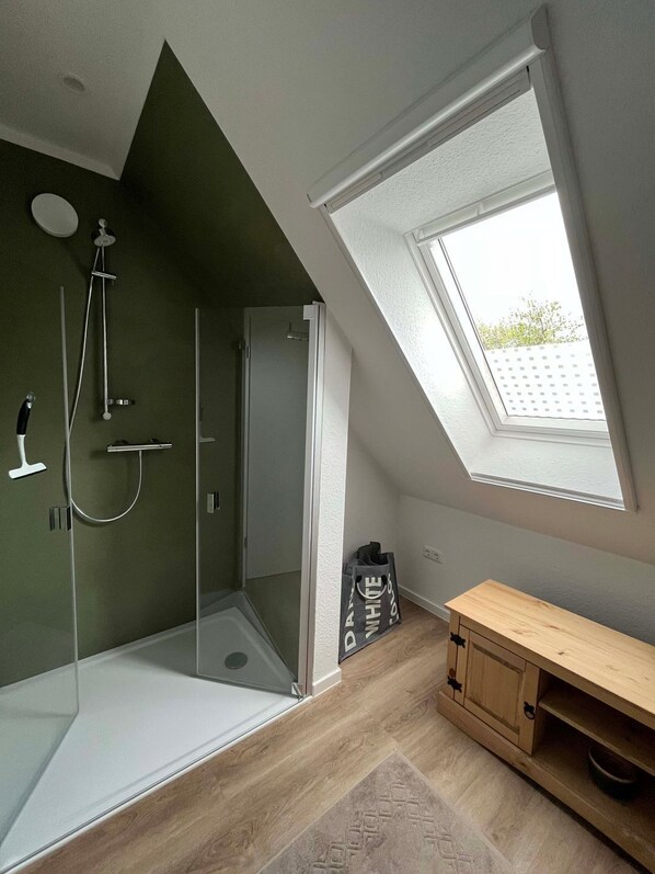 A modern bathroom with a skylight, a shower, and a wooden vanity. - Sonnenhuus Sanddorn - Neues Ferienhaus/ Doppelhaushälfte in Bester Lage in Werdum Gelegen, für max (Werdum)