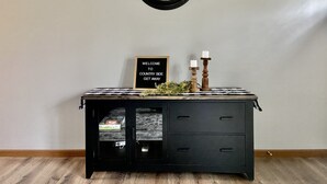 A wall clock, a welcome sign, and a wooden cabinet with drawers. - Country Getaway, 2- bedroom, Jacuzzi, fire ring (Woodbury)