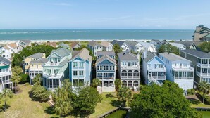 A coastal residential area with houses featuring balconies and a view of the ocean.