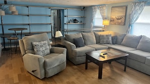 A modern living room with a sofa set, a coffee table, and a dining area with a small table and chairs. - Florida waterfront home with pool and use of kayaks (Ruskin)