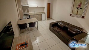 A compact living space with a kitchenette, a dining area, and a seating area. - RIVIERA PARK - JC TEMPORADA (Caldas Novas)