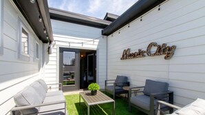 A patio with outdoor furniture, a small table, and a potted plant. - Stylish Rooftop Haven | Sleeps 12 Comfortably (Nashville)