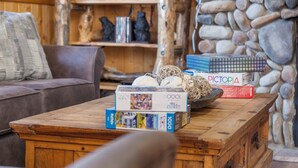 Een gezellige woonkamer met een houten salontafel, een bruine bank en een stenen muur.