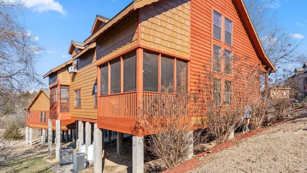 Een houten huis met balkon, schoorsteen en raam.