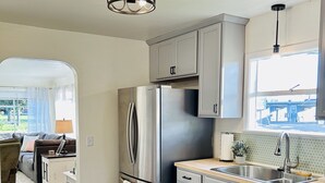 A modern kitchen with stainless steel appliances, grey cabinets, and a wooden countertop. - Remodeled, cozy, vintage charmer (Albany)