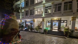 Entrada de hotel con pavimento de baldosas hexagonales, un refrigerador de Coca-Cola y un letrero que dice "DURARIN".
