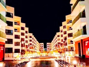 A modern hotel with a central courtyard, multiple floors, and a well-lit facade.