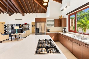A modern kitchen with a central island, stainless steel appliances, and wooden cabinetry.