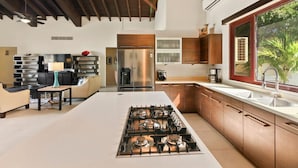 Une cuisine moderne dotée d’un îlot central, d’appareils électroménagers en acier inoxydable et de meubles en bois.