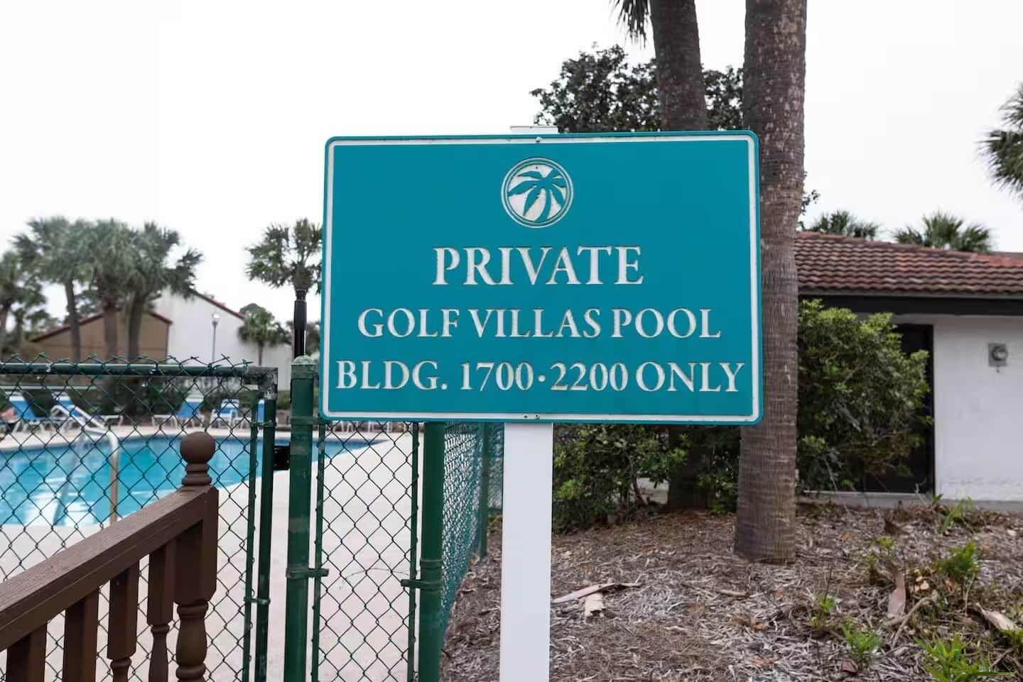 A sign indicating a private golf villas pool area with a specific address.