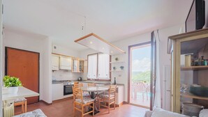 Eine moderne Küche mit Essbereich, einer Couch und einem Balkon mit Blick.