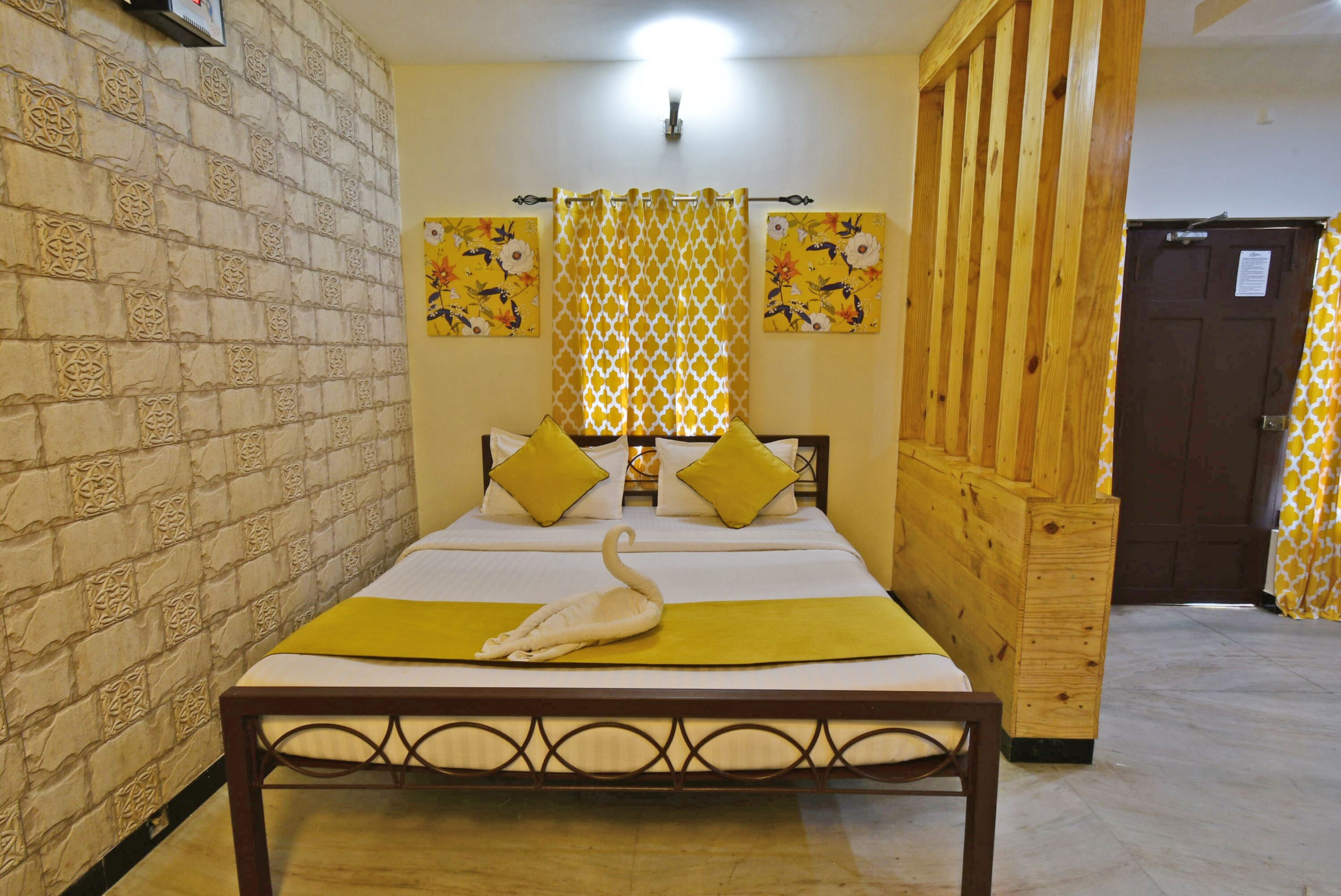 A neatly arranged bedroom with a bed, a swan decoration, and floral artwork on the walls.