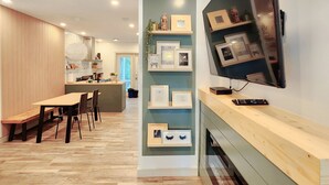 A modern kitchen with a wooden bench and chairs, a dining table, and a TV mounted on the wall. - The overlook stay | Free parking｜12 (Harvie Heights)