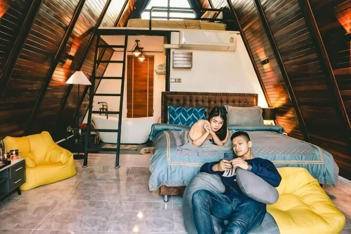 Une chambre à coucher avec un lit, une échelle, une fenêtre et une chaise jaune.