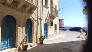 A narrow street with buildings featuring arched doorways and balconies. - New LOFT on Ortigia waterfront for max 3 guests (siracusa)