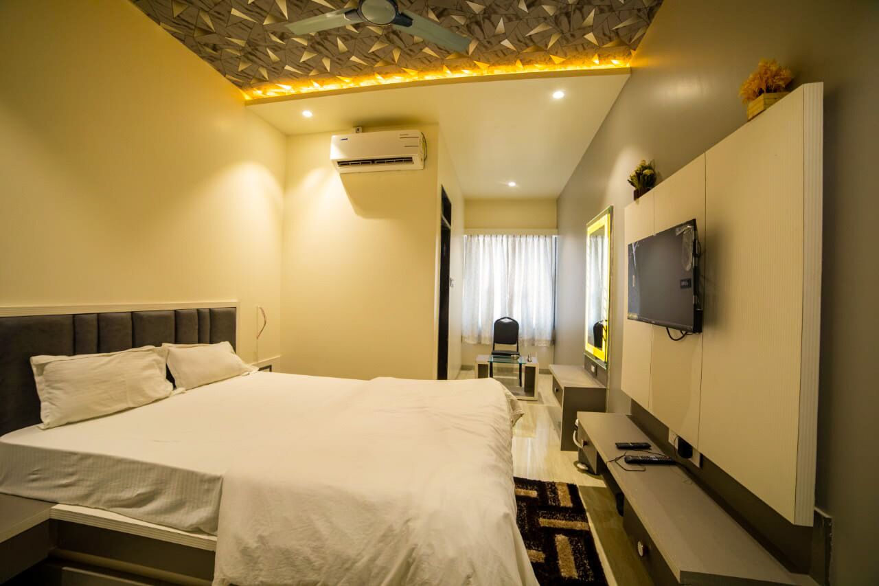 Une chambre d’hôtel équipée d’un lit, d  ’une table de chevet, d’une télévision et d’un appareil de climatisation.