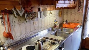 Eine Küche mit Holzschränken, einem Edelstahlherd und einer Spüle.
