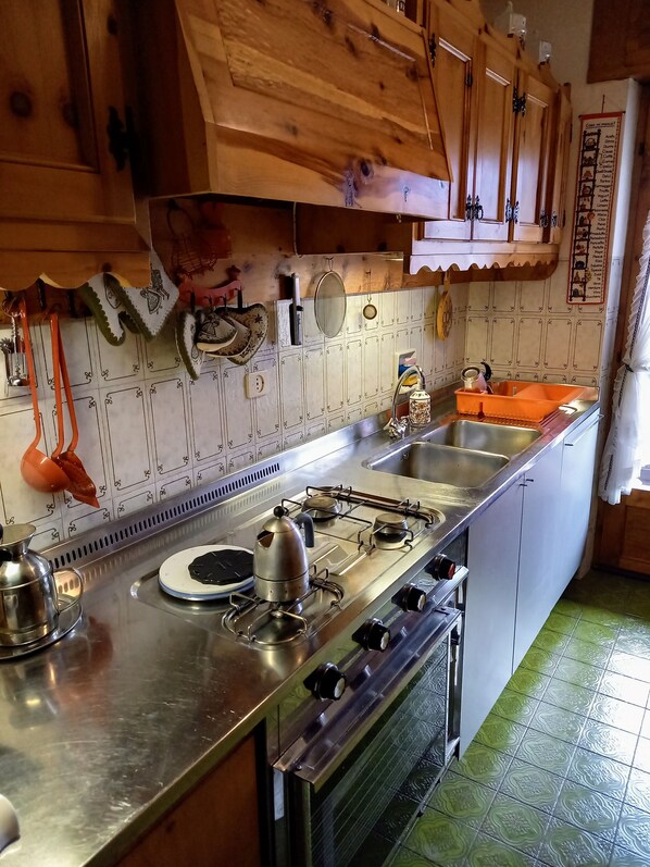 Ett kök med träskåp, en spis i rostfritt stål och en diskho.