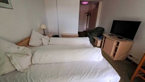 A hotel room with a bed, a television on a wooden cabinet, and a chair. - Hotel Iadolina (Budureasa)