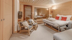 Une pièce en bois avec un lit, un canapé et un téléviseur.