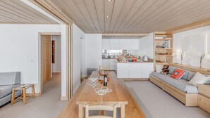Un intérieur moderne avec une table à manger en bois, un canapé et un coin cuisine.