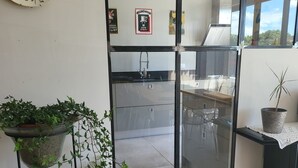 Una cucina moderna con una parete divisoria in vetro, una pianta sospesa e un piatto decorativo al muro.