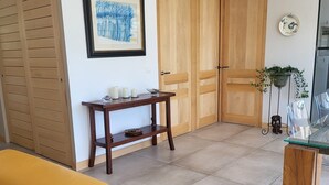 Un soggiorno moderno con un divano giallo, porte in legno, un quadro incorniciato e un tavolino con candele.