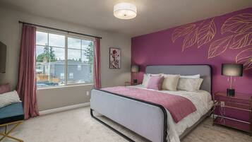 A bedroom with a bed, a nightstand, a lamp, a window with curtains, and a wall with a leaf pattern.