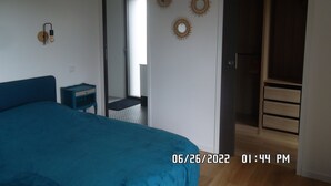 Un dormitorio con cama, escritorio y armario.