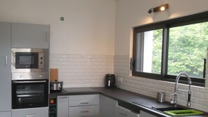 Una cocina compacta con microondas, horno y lavaplatos.