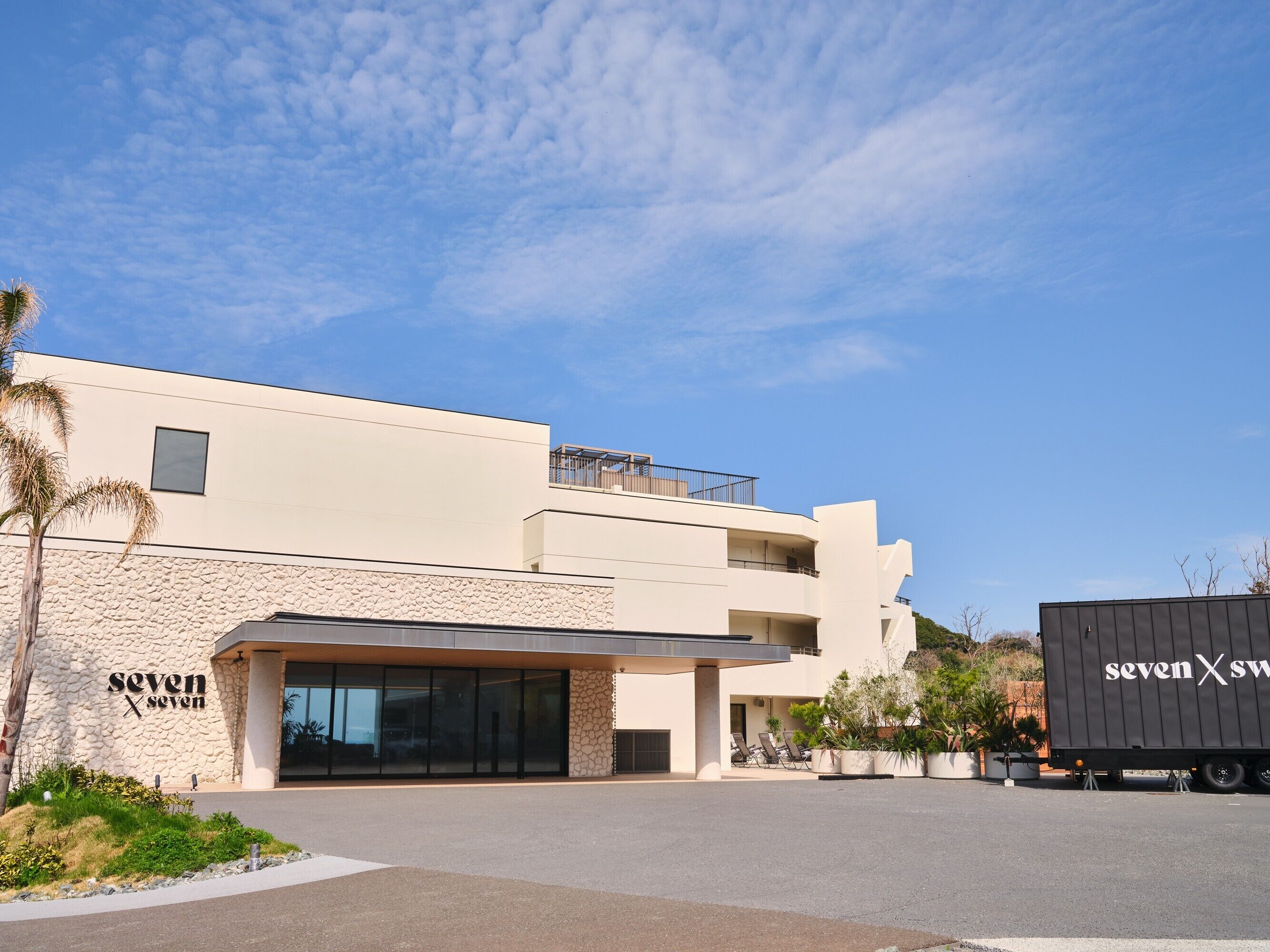 A modern building with a stone facade, a flat roof, and a large entrance.