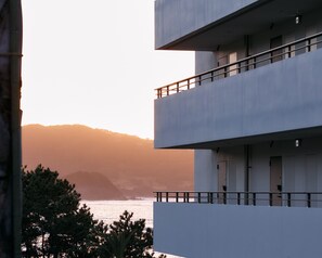 A multi-story building with balconies overlooking a coastal area.