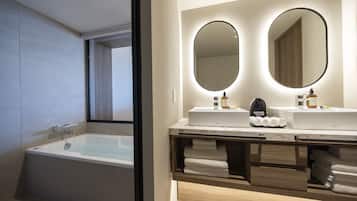 A modern bathroom with a bathtub, two sinks with mirrors, and neatly folded towels.
