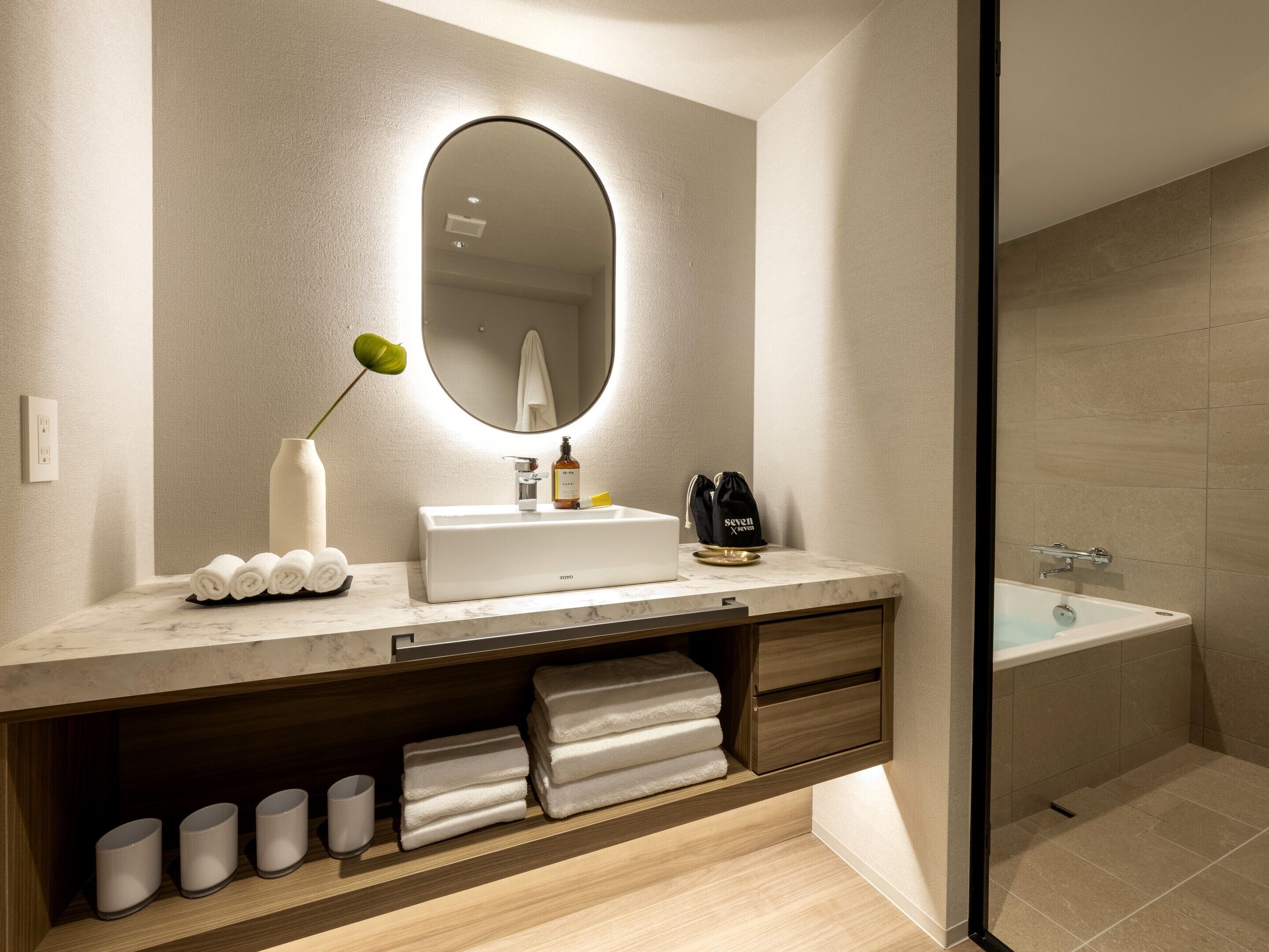 Ein modernes Badezimmer mit Waschbecken, Spiegel und einer Duschkabine.