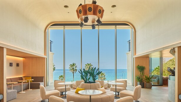 A modern interior with a large window overlooking the sea, furnished with sofas and round tables. - seven x seven Itoshima (Fukuoka)
