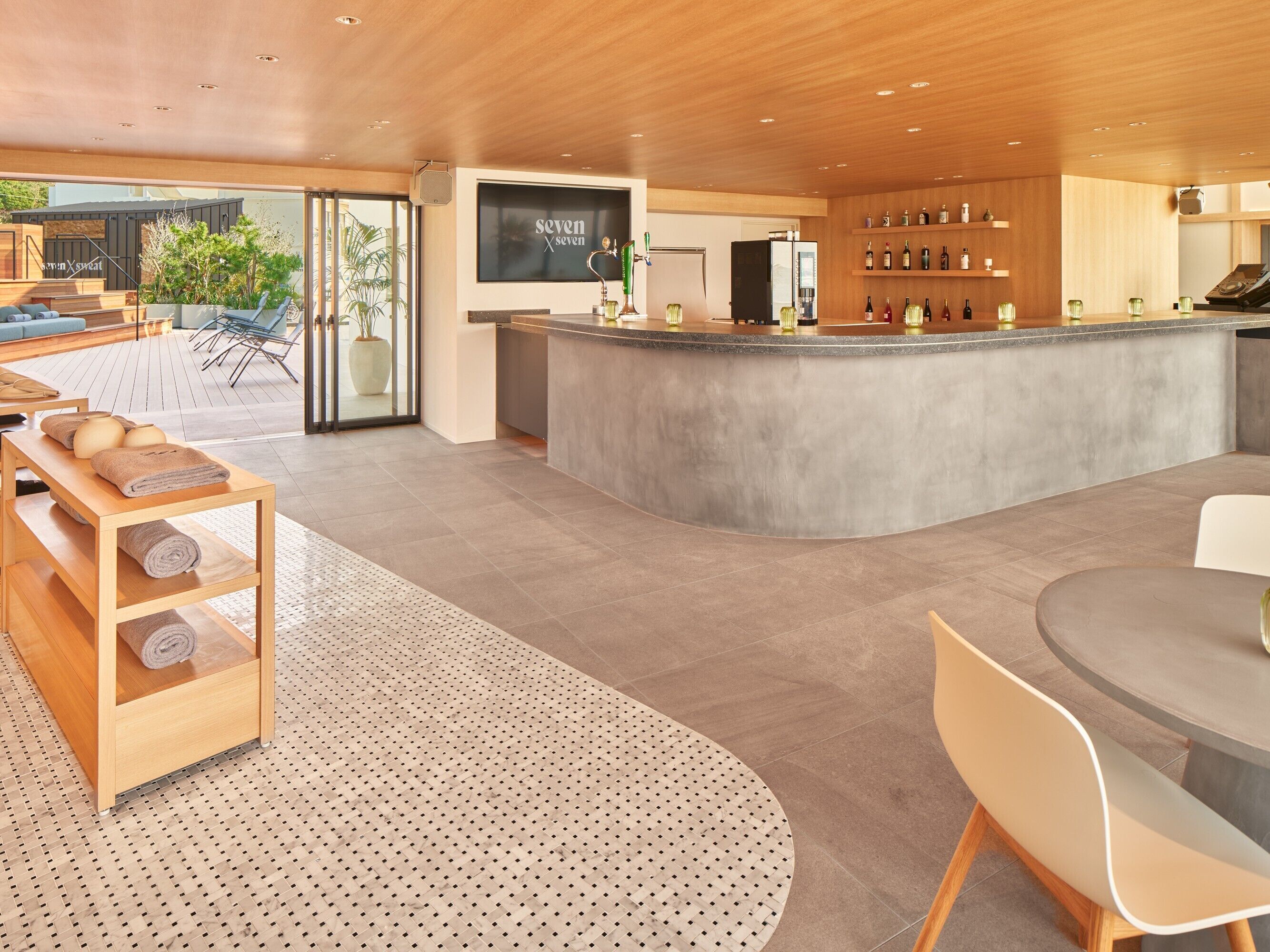 A modern bar area with a counter, seating, and a view of the outdoors.