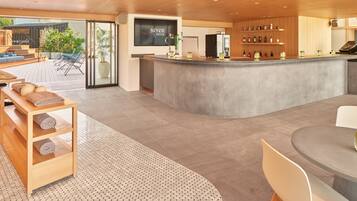 A modern bar area with a counter, seating, and a view of the outdoors.